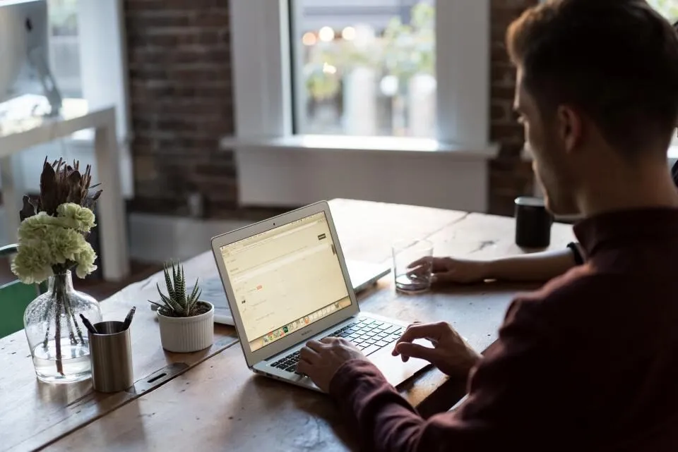 An agent typing at a desk by a window