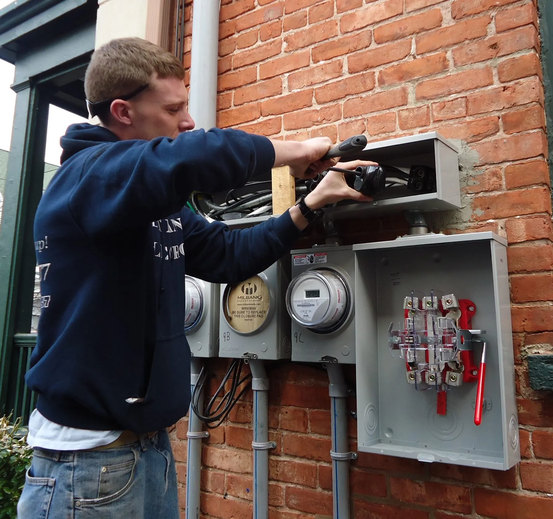 An electrician working on an outdoor panel